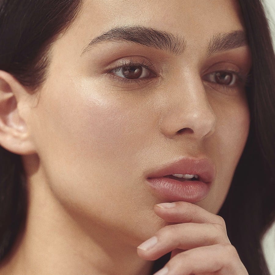 Model with soft smooth hydrated lips after using Henné Organics Luxury Lip Balm