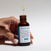 Load image into Gallery viewer, Hand holding a dropper of SkinCeuticals CE Ferulic Antioxidant Serum
