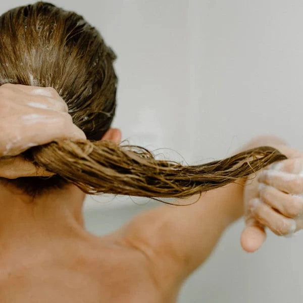 Person washing hair with a white background