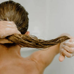 Person washing hair with a white background