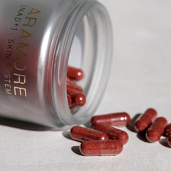 Aramore supplement jar with red capsules on a white surface