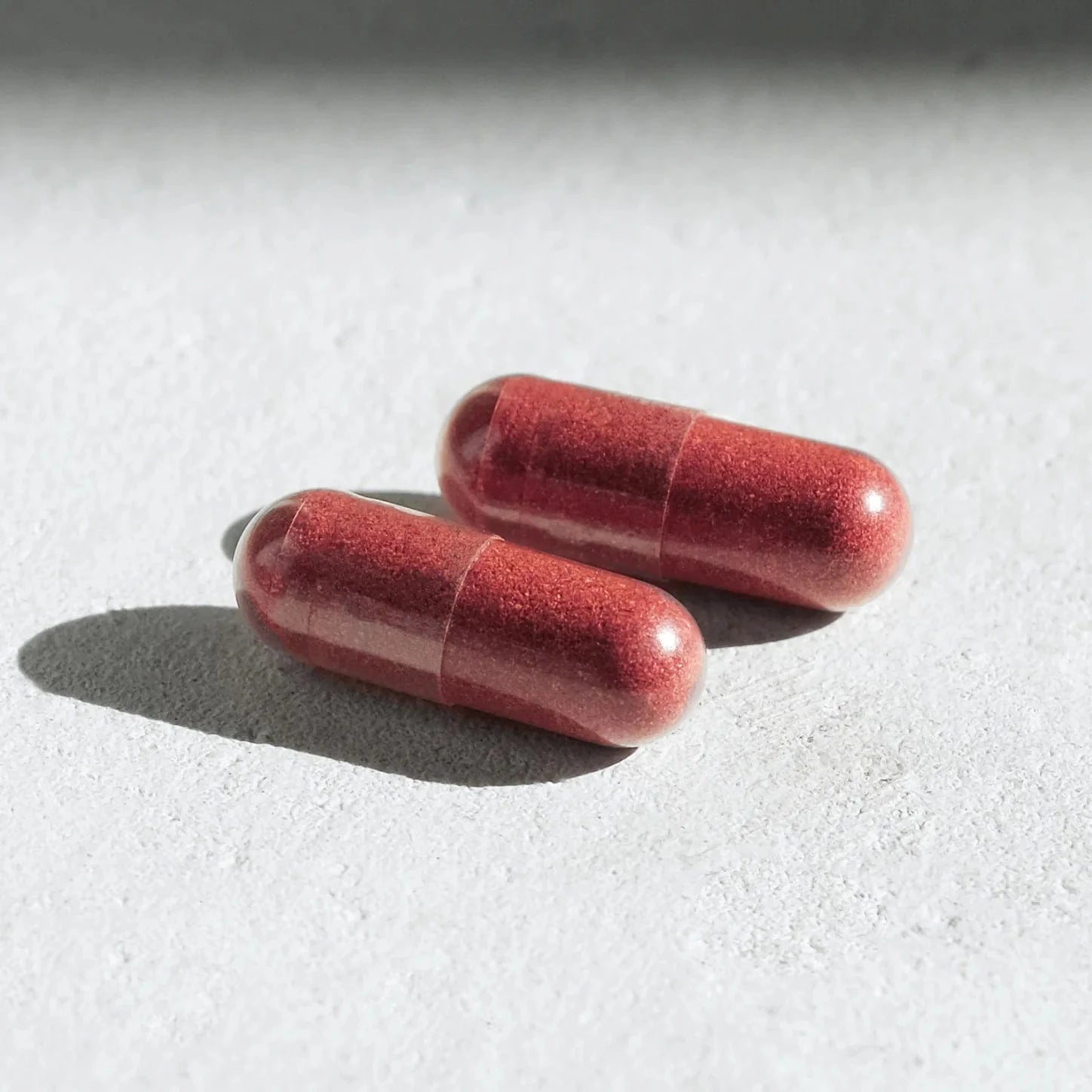 Aramore Two red capsules on a light gray surface