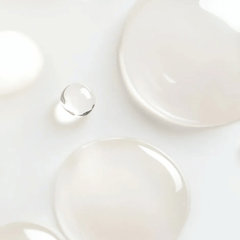 Close-up of lightweight reparative serum droplets on white surface showing silky texture