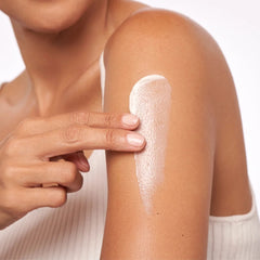 Woman applying ALASTIN Skincare TransFORM Body Treatment firming cream to upper arm