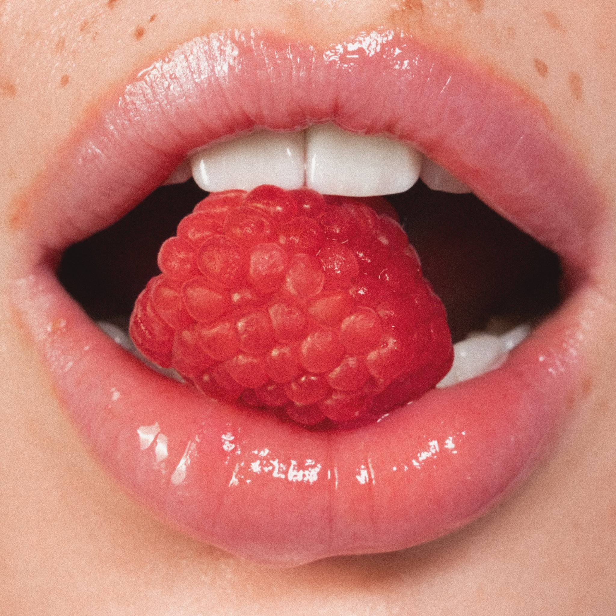 Anfisa Skin AN-Gloss Ceramide Lip Tint Berry Crumble glossy lips holding raspberry closeup 5