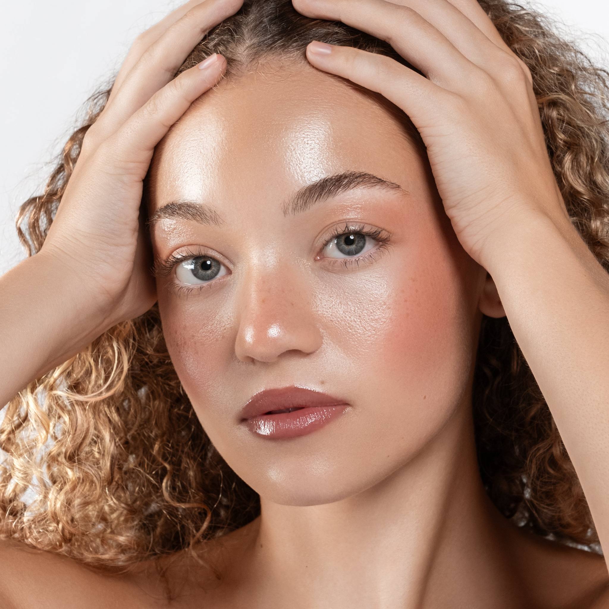 Model with curly hair wearing Anfisa Skin AN-Gloss Ceramide Lip Tint Spice Cake glossy lips portrait 5