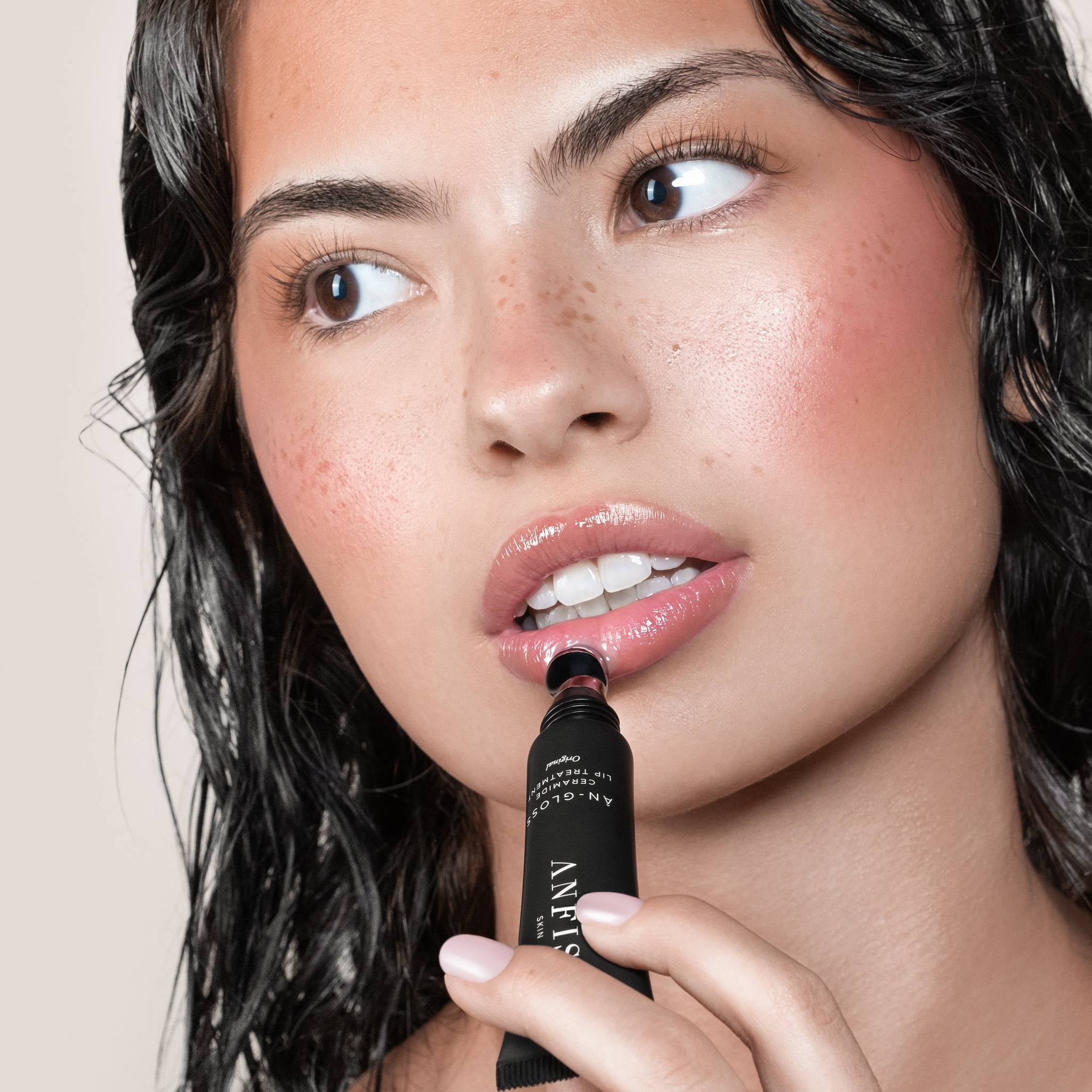 Model with dark hair applying Anfisa Skin AN-Gloss Ceramide Lip Treatment Original for glossy lips 3