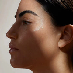 Close-up of a woman's face with a focus on her eye and eyebrow area.