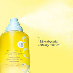 Milk Shake bottle spraying an ultra fine mist against a yellow background