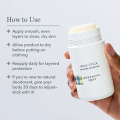 Hand holding an open Beekman 1802 Milk Stick deodorant showing how to apply it to clean skin
