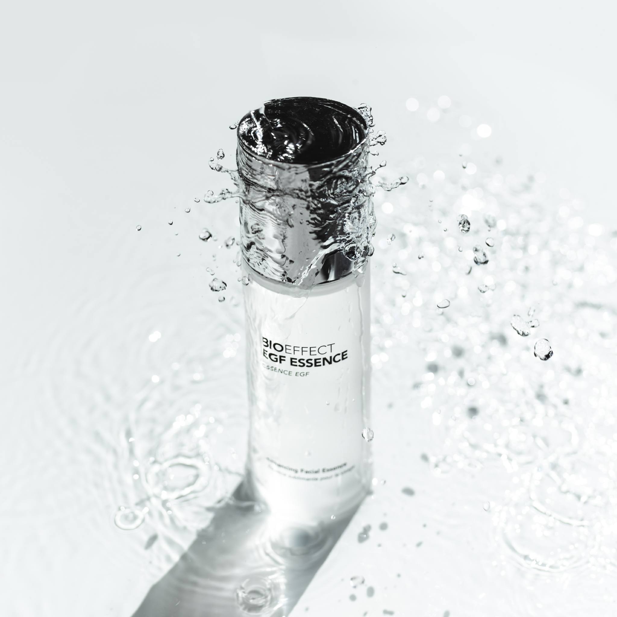 BIOEFFECT EGF Essence bottle surrounded by dynamic water splash highlighting hydrating facial essence formula