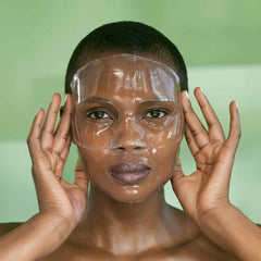 Model wearing BIOEFFECT Imprinting Hydrogel Mask full-face hyaluronic acid sheet mask on green background