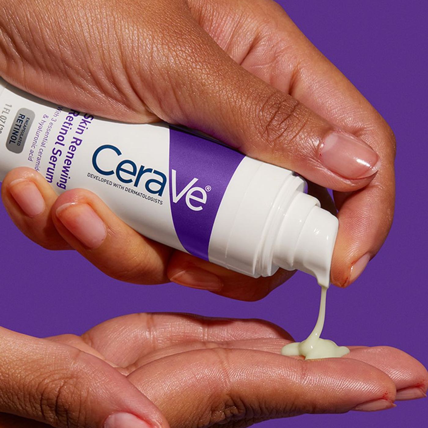 Hand pumping CeraVe Skin Renewing Retinol Serum into palm on a purple background