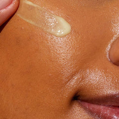 Close-up of CeraVe retinol serum texture swatched on cheek showing a lightweight smoothing face serum