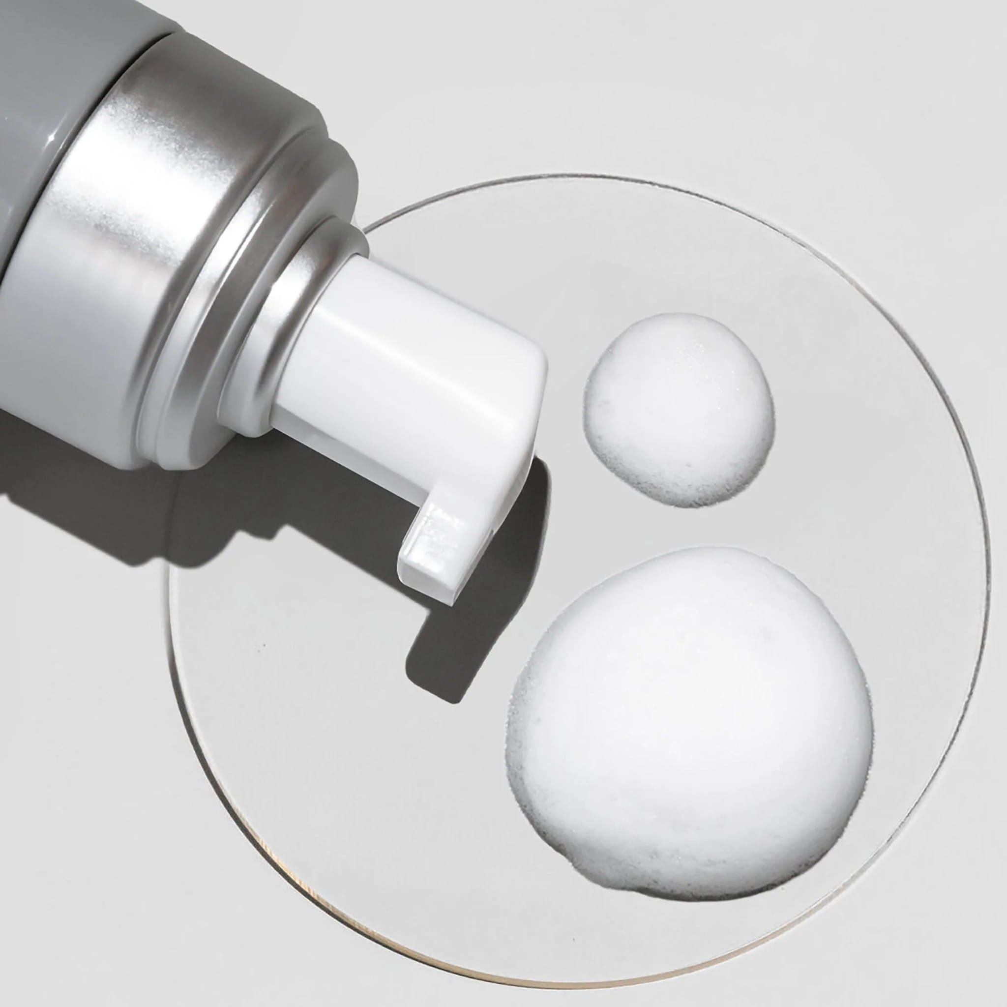 Cosmedix Clarify foaming cleanser foam swatch shown beside its pump