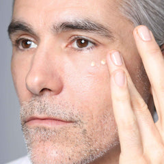 Man applying Cosmedix Eye Doctor high potency eye treatment under his eye