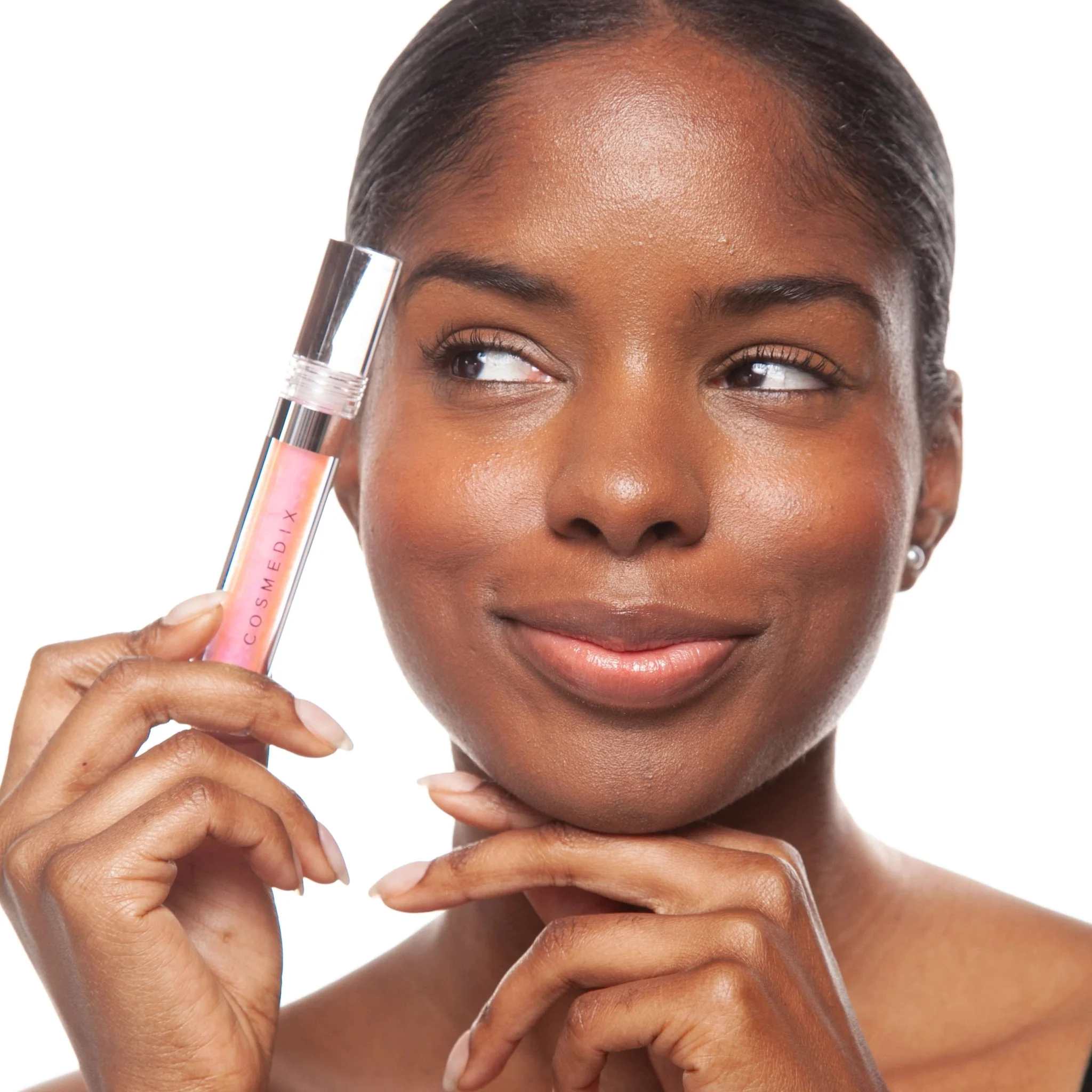 Woman holding Cosmedix Lumi Crystal liquid lip hydrator near her face