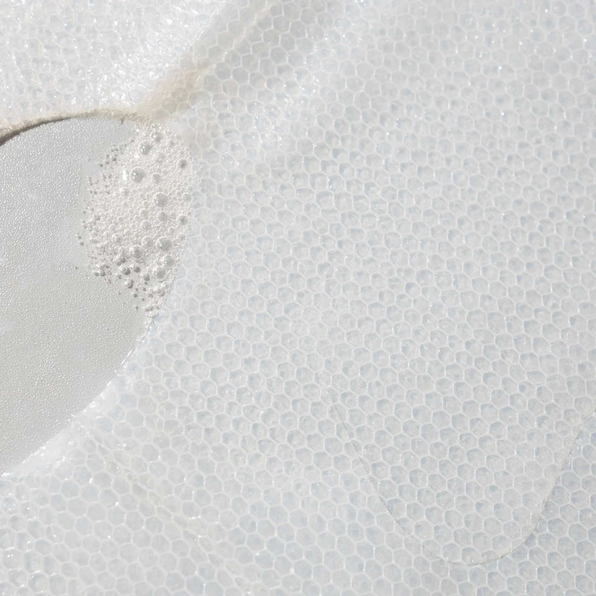 Close-up of Cosmedix Micro Defense sheet mask fabric with serum bubbles