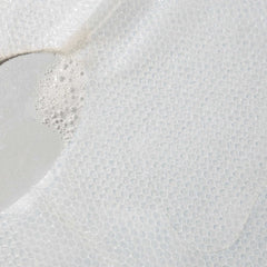 Close-up of Cosmedix Micro Defense sheet mask fabric with serum bubbles