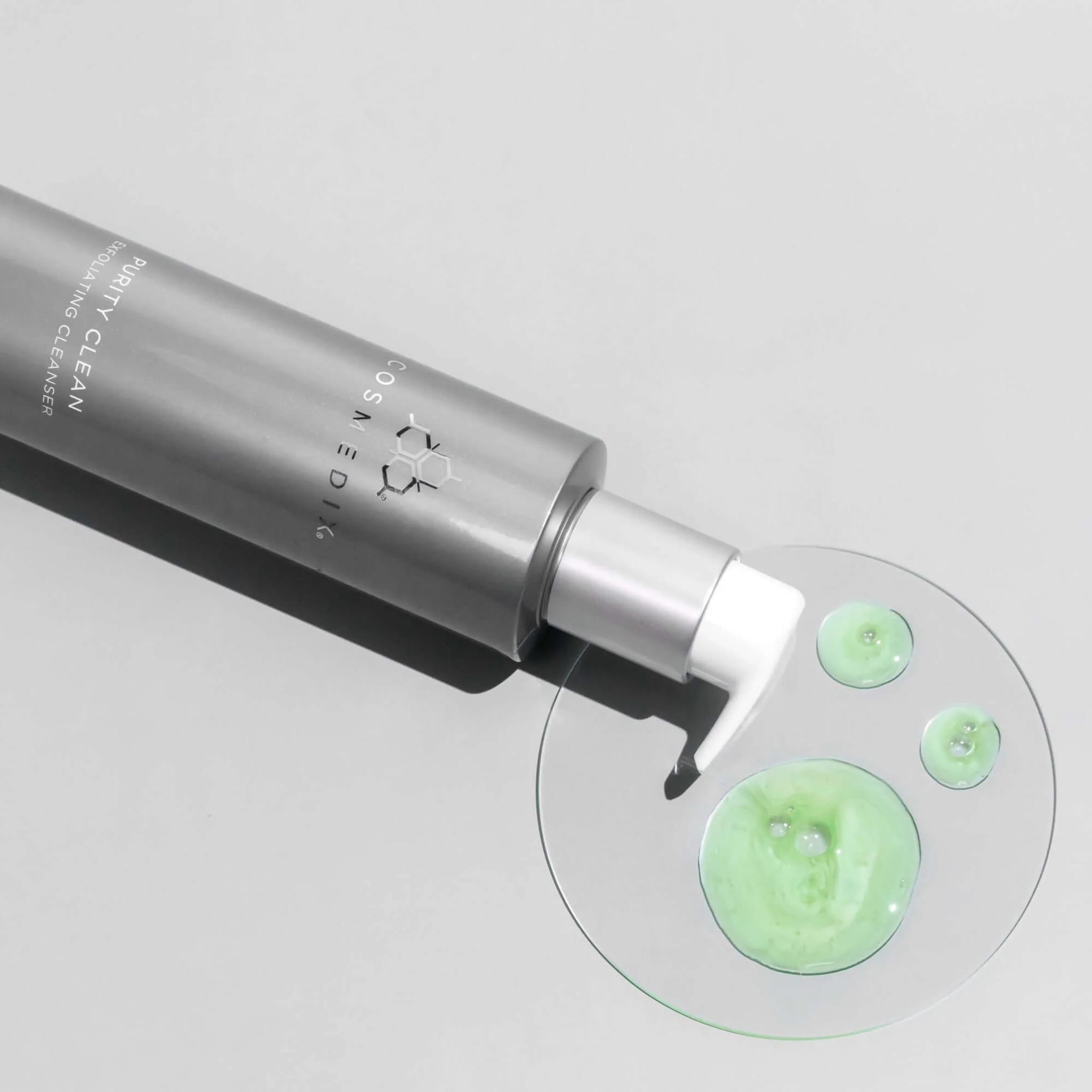 Cosmedix Purity Clean exfoliating cleanser texture drops beside its bottle