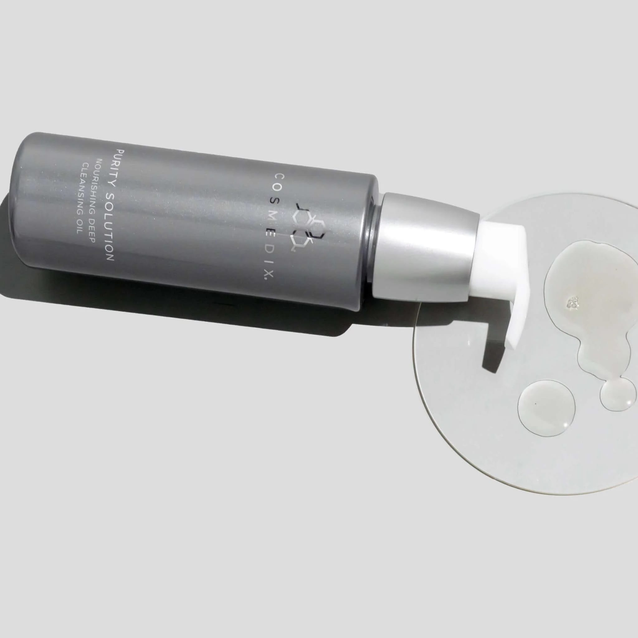 Cosmedix Purity Solution deep cleansing oil texture droplets beside bottle