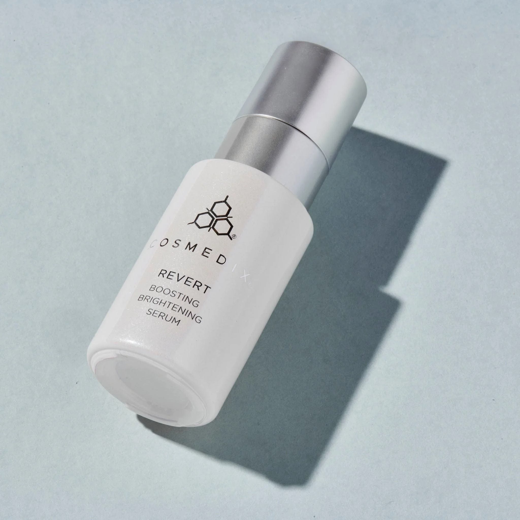 Cosmedix Revert boosting brightening serum bottle on blue background