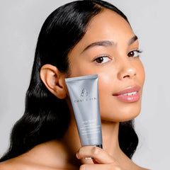 Woman holding Cosmedix Skin Thirst hyaluronic acid cream near her face