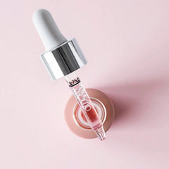 Filorga NCEF-Shot glass dropper applicator with pink anti-ageing serum concentrate on pink background