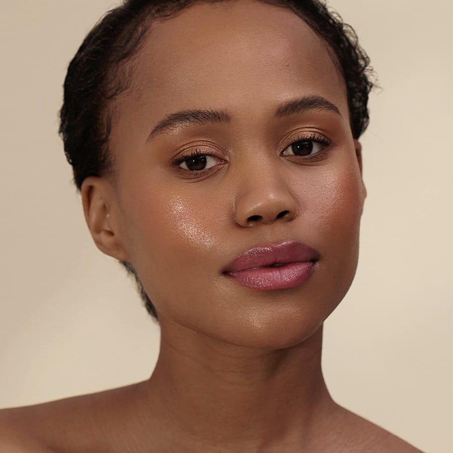 Woman with short curls wearing Henné Organics Luxury Lip Tint in Blissful for a soft berry lip 2