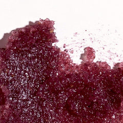 Swatch of Nordic Berries lip exfoliator showing fine sparkling sugar crystals in a deep berry tone