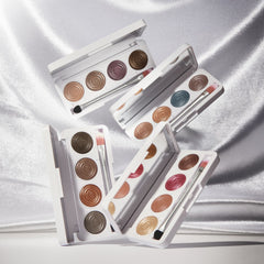 Four Hydra Eyes Quartet eyeshadow palettes open and styled together on satin fabric 7