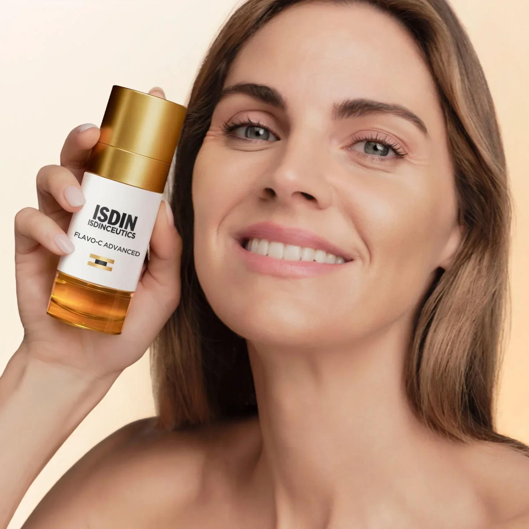 Woman holding ISDIN Flavo-C Advanced vitamin C serum next to her face