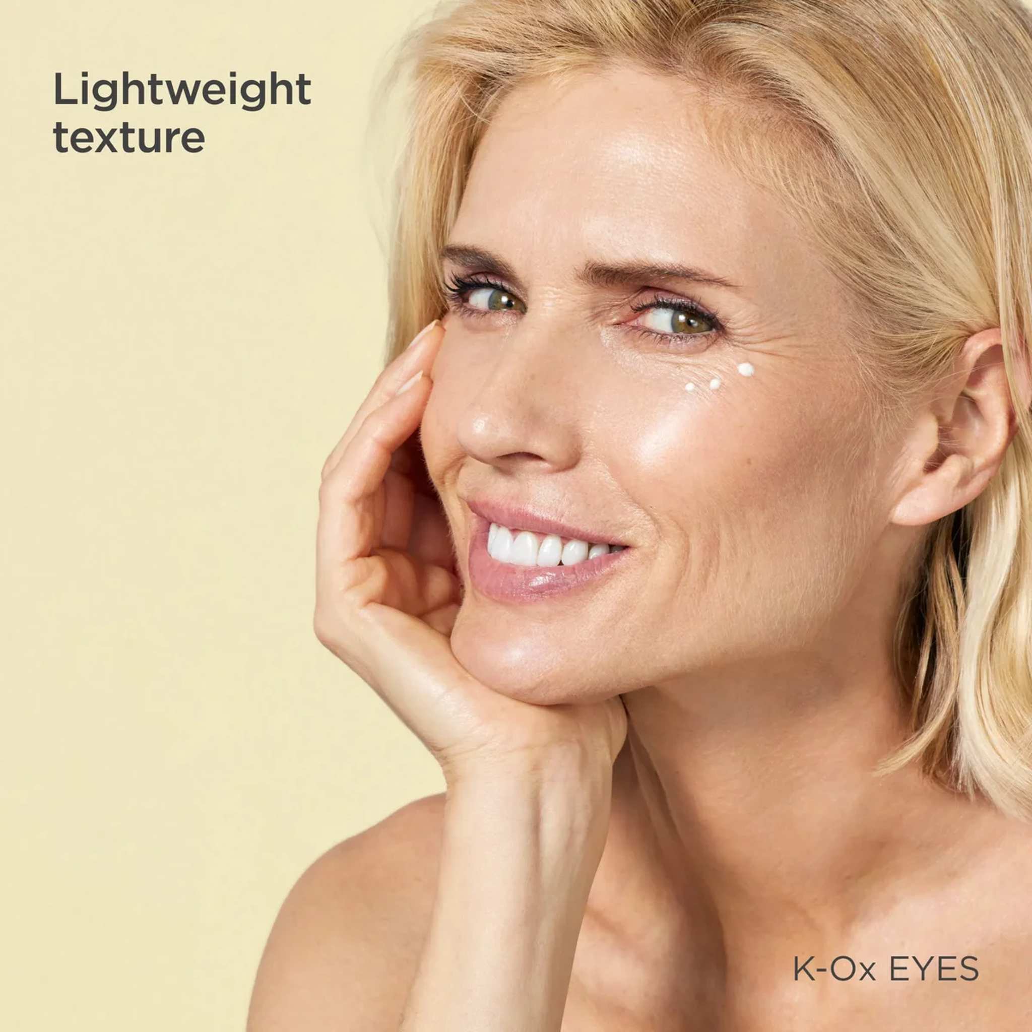Smiling woman with dots of ISDIN K-Ox Eyes lightweight eye cream under her eye