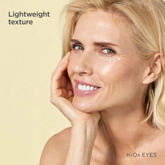 Smiling woman with dots of ISDIN K-Ox Eyes lightweight eye cream under her eye
