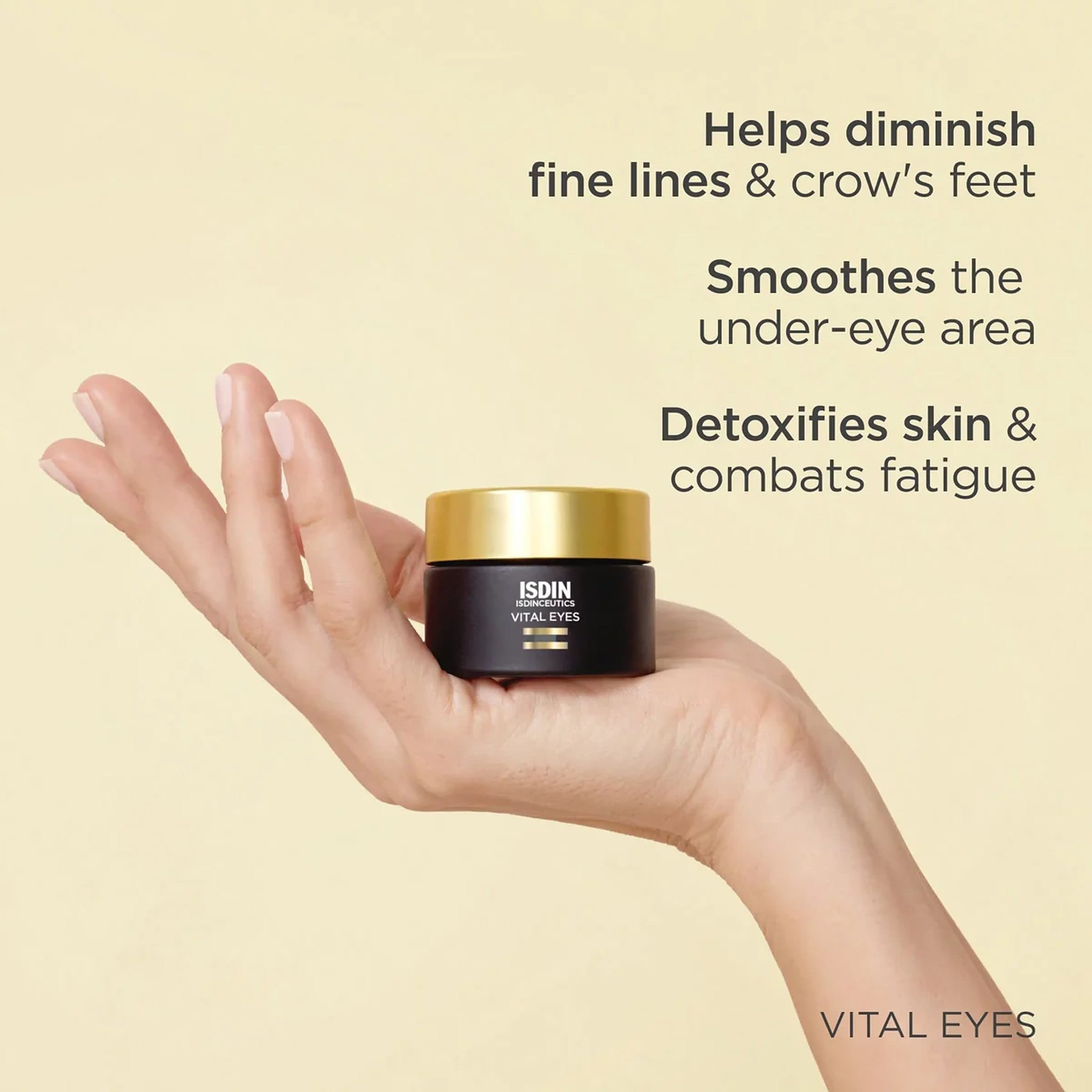 Hand holding ISDIN Vital Eyes eye cream jar that helps smooth fine lines and crow’s feet and combat under-eye fatigue