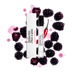 Juliette Has a Gun Purple Trouble perfume and travel spray in front of a giant blackberry