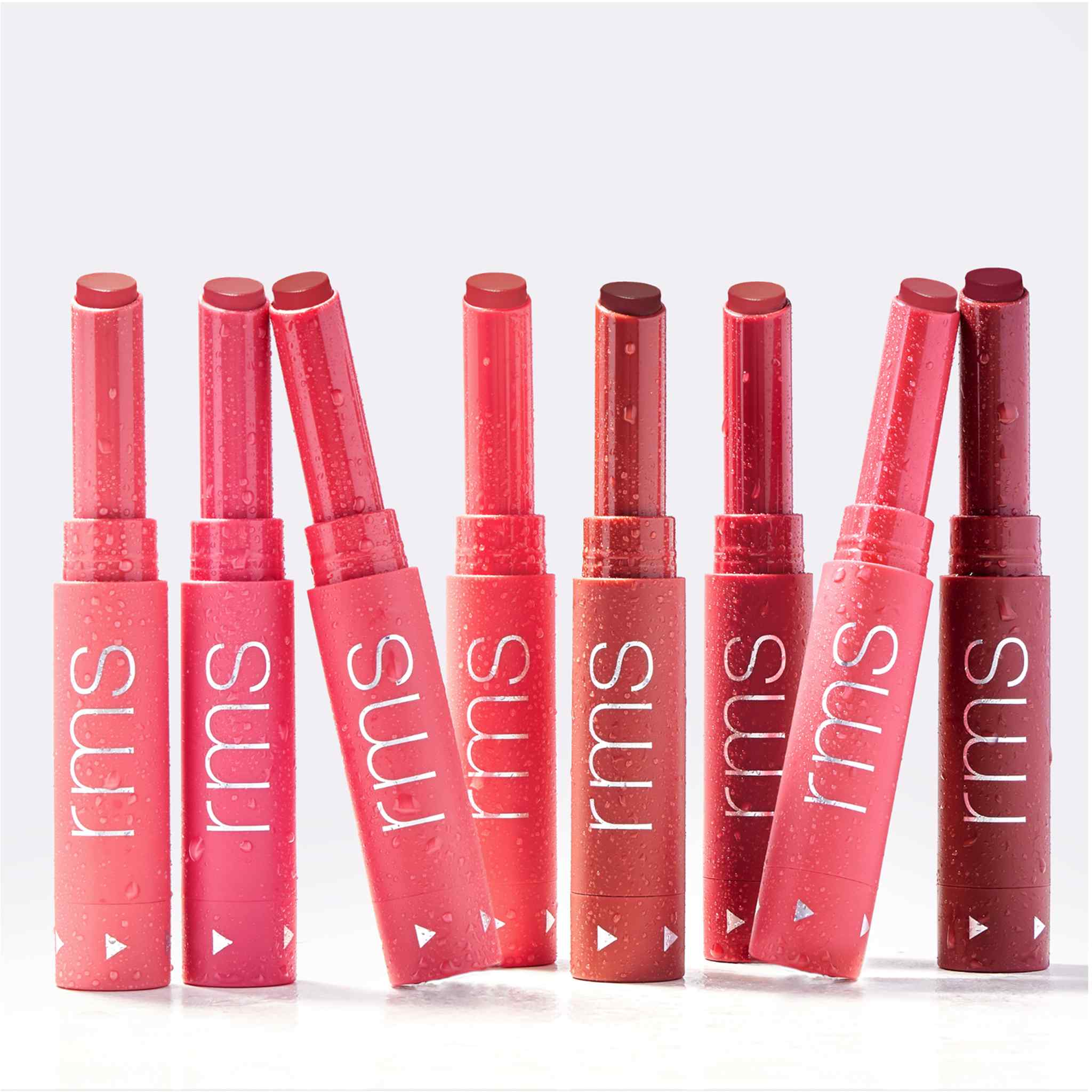 Eight Legendary Serum Lipstick shades standing upright with water droplets 8
