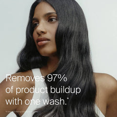 Woman with long glossy dark hair showing Living Proof Clarifying Detox Shampoo removing 97 percent of product buildup