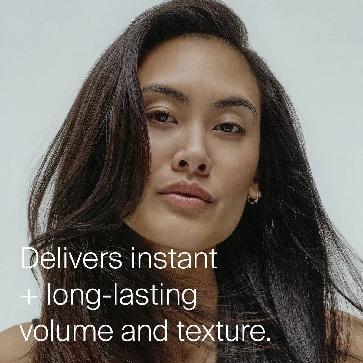 Woman with long voluminous dark hair showing instant long lasting volume and texture from Living Proof Full Dry Volume Spray