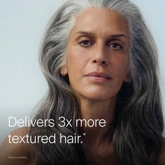 Woman with long gray waves showing Living Proof Full Texturizing Foam delivering 3x more textured hair