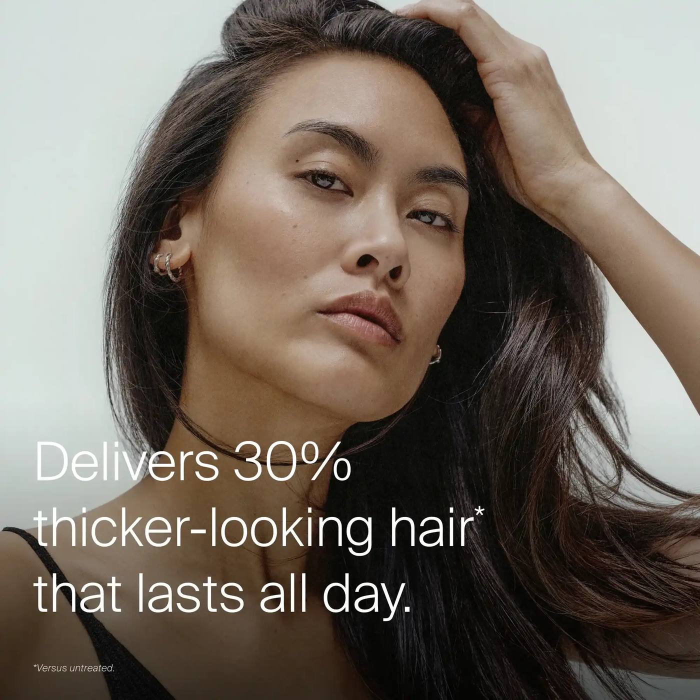 Woman with long dark hair showing Living Proof Full Thickening Blow-Dry Cream for 30 percent thicker-looking hair
