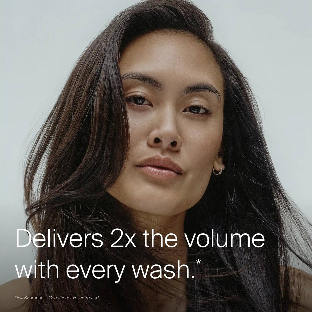 Woman with voluminous dark hair after Living Proof Full Shampoo and Conditioner delivering 2x the volume
