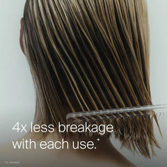 Comb gliding through wet highlighted hair showing Living Proof Leave-In Conditioning Spray for 4x less breakage