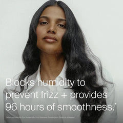 Woman with long glossy dark waves showing Living Proof No Frizz blocking humidity for 96 hours of smoothness
