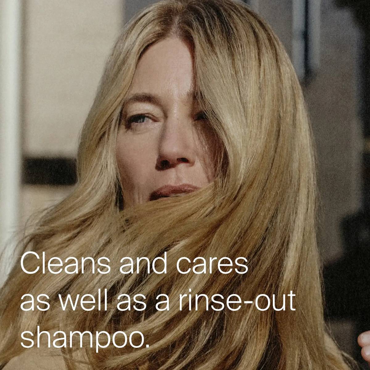 Woman with long glossy blonde hair showing Advanced Clean Dry Shampoo cleans and cares like a rinse-out shampoo