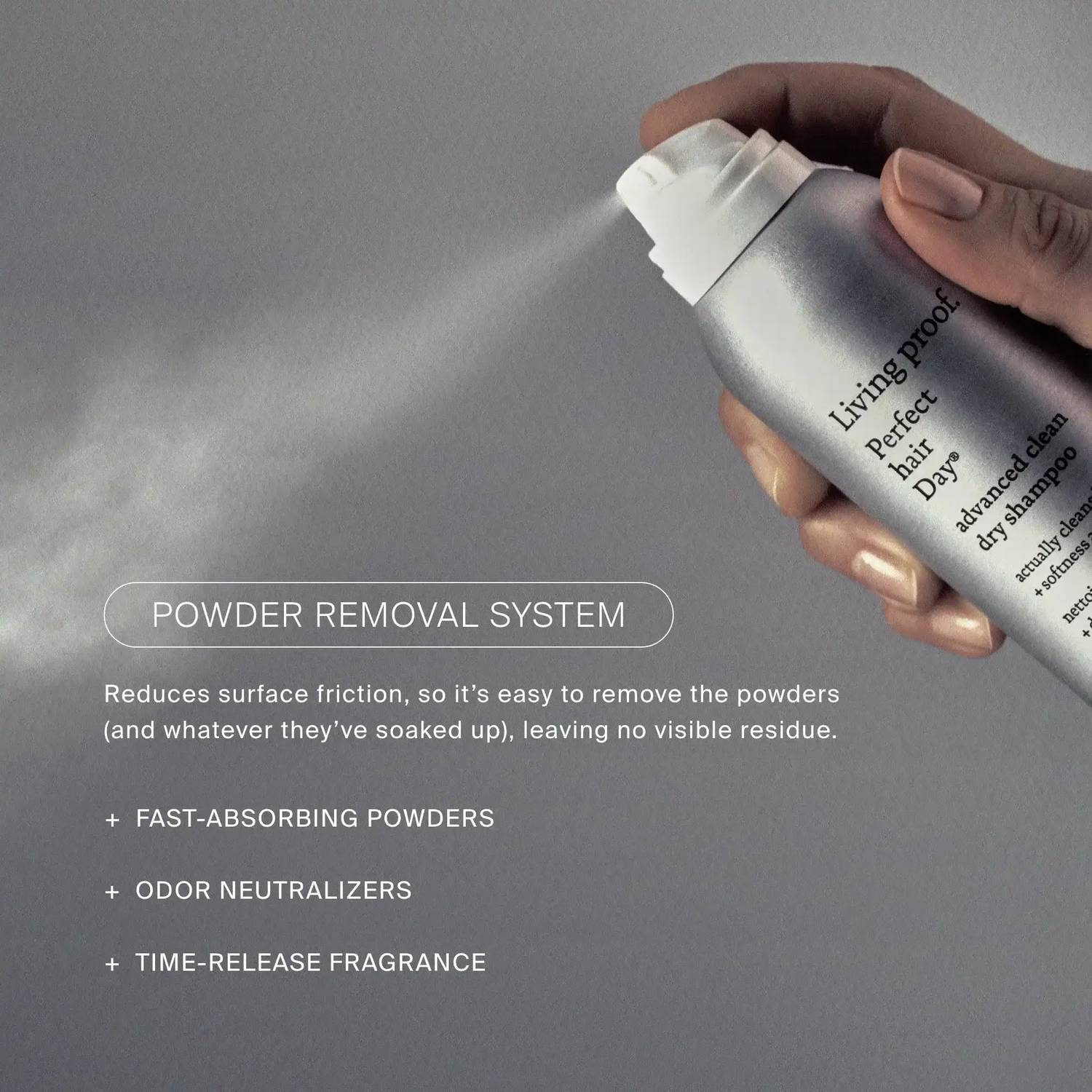 Hand spraying Living Proof Advanced Clean Dry Shampoo with powder removal system odor neutralizers and fragrance