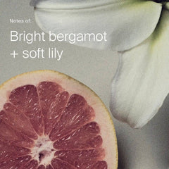 Grapefruit half and white lily petals showing the bright bergamot and soft lily scent of Heat Styling Spray