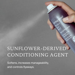 Hand spraying Perfect hair Day Heat Styling Spray with a sunflower-derived conditioning agent to soften and tame flyaways