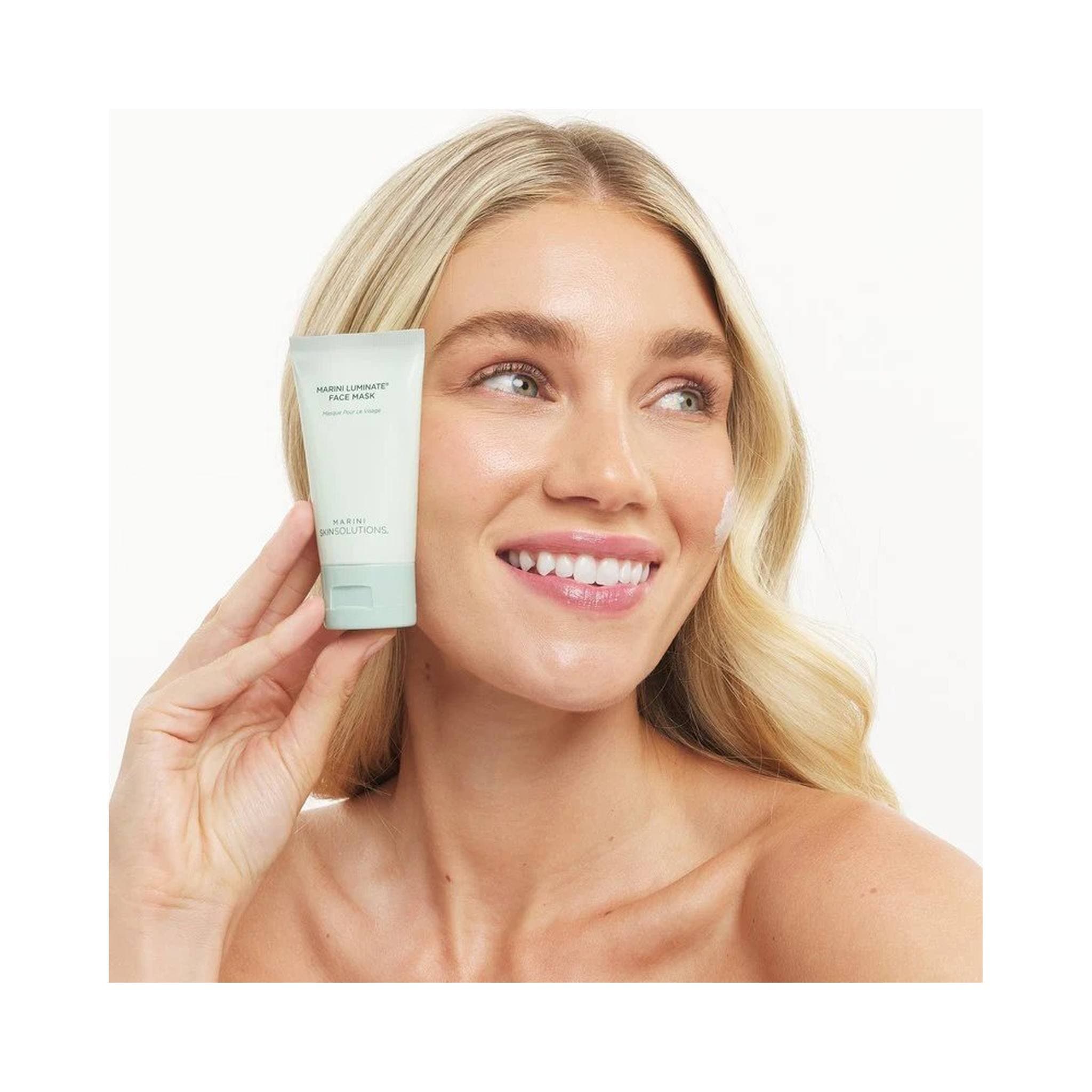 Model applying Marini Skin Solutions Marini Luminate Face Mask brightening skincare treatment