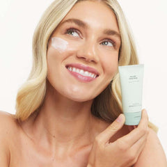 Woman applying Marini Skin Solutions HYLA3D Face Mask with product tube held near glowing skin